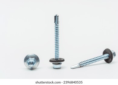 roofing screws on a white background. photo of self-tapping screws for the catalog on a light background. set of bolts for working with metal tiles and iron