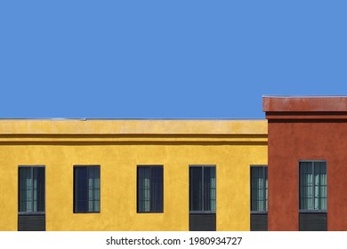 Roofline section of a larger red and yellow building and blue sky