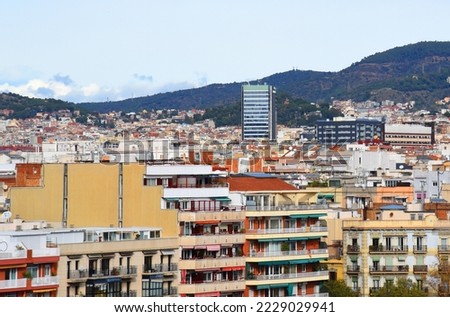 Roofs of buildings. Barcelona Spain, high angle view city skyline. Mountains skyline. Rooftop view in Barcelona. Facade of old residential building at hills and mountain. Historic building in rock.