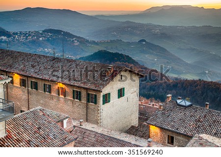 Roofs of houses of the Republic of San Marino in a winter sunset over the foggy valley