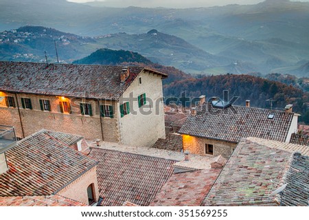 Roofs of houses of the Republic of San Marino in a winter sunset over the foggy valley