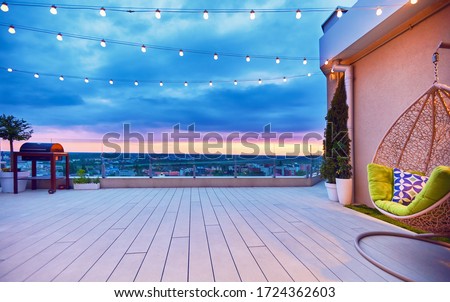 rooftop deck patio area with hanging chair on a sunset