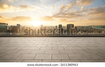 Rooftop empty brick floor with panoramic city skyline during sunset.
