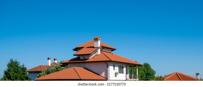 Rooftop And Exterior Of A Newly Built Big Family House. Real Estate Concept. Luxury And Expensive Home Exterior Against Clear Blue Sky With Room For Text.