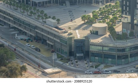 Rooftop Garden With Palms Near Entrance To Office Towers In Financial District Of Dubai City Evening Timelapse. Aerial View With Road And Parking