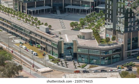 Rooftop Garden With Palms Near Entrance To Office Towers In Financial District Of Dubai City Morning Timelapse. Aerial View With Road And Parking