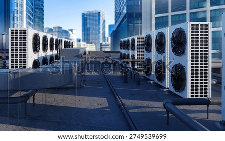 Rooftop HVAC units and ventilation systems on modern city building. Industrial air conditioning infrastructure in urban commercial district.