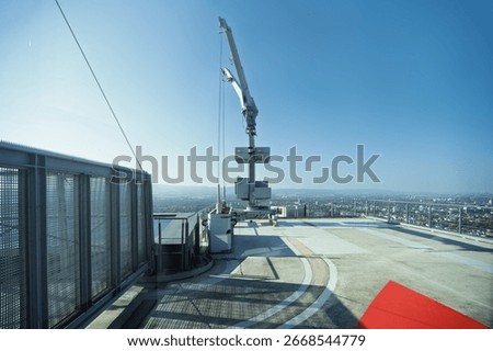 A rooftop maintenance crane or facade Access system on top of a high-rise building, overlooking a cityscape