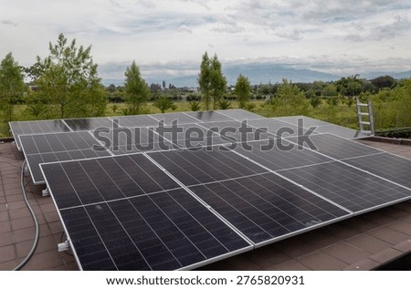 Rooftop solar panel installation generating clean electricity with natural landscape in the background. Sustainable energy solution for residential use, promoting renewable power and environmental responsibility. Ideal for concepts of green energy, technology, efficiency and eco-friendly living.
