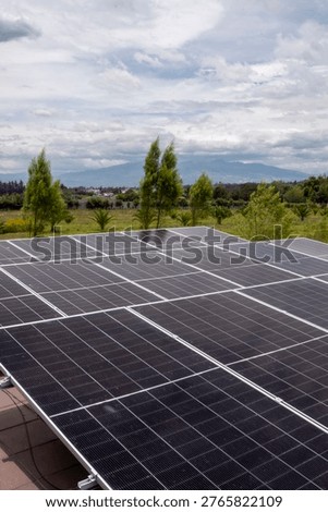 Rooftop solar panel installation generating clean electricity with natural landscape in the background. Sustainable energy solution for residential use, promoting renewable power and environmental responsibility. Ideal for concepts of green energy, technology, efficiency and eco-friendly living.