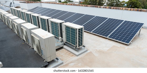 rooftop solar panels and air conditioning on top of an apartment block