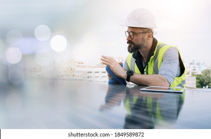 Rooftop solar power plant engineers sitting and examining photovoltaic panels. Concept of alternative energy and its service. Engineer energy power man worker at site. - Shutterstock ID 1849589872