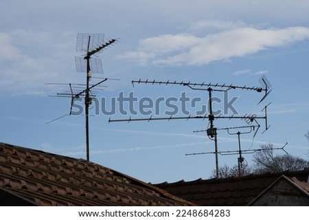 The rooftops made of red tiles with analog antennas attached to the roofs. There is blue sky is on background with some white clouds with a lot of copy space. Stock photo © 