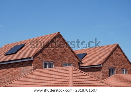 Rooftops of new build houses with solar panels. Newly constructed homes in residential development in the UK  