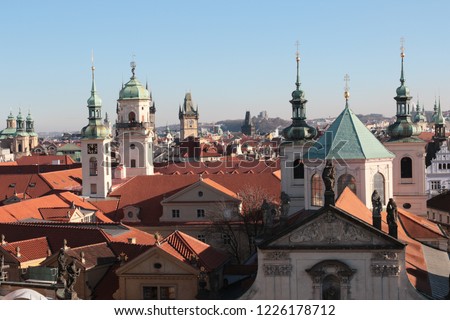 The rooftops of Prague in Winter showing the red tiled rooves and the church spires