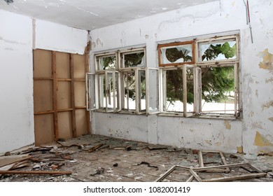 Room In Abandoned Building With Broken Windows, Destroyed Floorboards And Dilapidated Wall Insulation