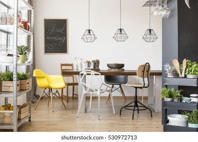 Room with communal table, chairs, industrial regale and cart
