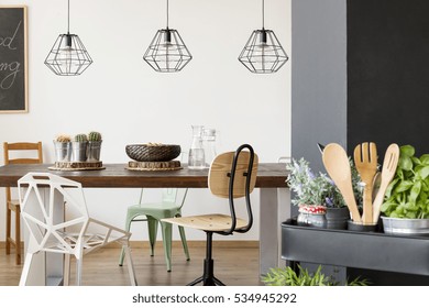 Room With Communal Table, Chairs, Pendant Lamps, Kitchen Cart