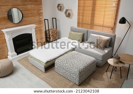 Room interior with sleeper sofa near fireplace