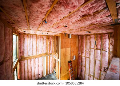Room interior walls with pink color thermal insulation installed prior to drywall installation