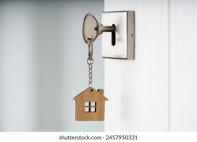 Room key and a house-shaped keychain. An open door. Real estate investment concepts - Powered by Shutterstock