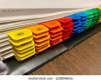 Room Numbers On Colored Tabs Inside A 3 Ring Binder.