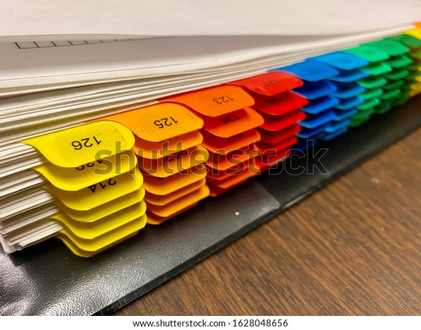 Room\
numbers on colored tabs inside a 3 ring\
binder.