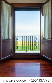 Room With Open Balcony Doors And Nice Views Of A Green Meadow, The Calm Sea And Blue Sky. 