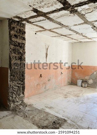 room in the process of remodeling or partial demolition. You can see a wall from which part of the finish has been removed, leaving the adobe bricks exposed in one of its corners.