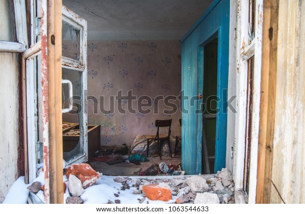 Room of ruined house with dirty distorted remains\
of home stuff