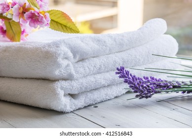 Room Service And Spa Hotel Concept. Towels And Flowers Against A Sunny Background.