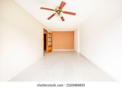 Room With Two-tone Paintings On The Walls, Fan Lamp And Dark Mahogany Wood Doors