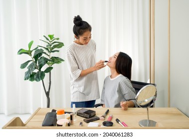 Roommates have fun learning to make-up for asian friends. Enjoy leisure weekend at home. - Shutterstock ID 2040061283
