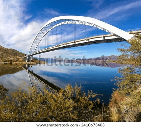 Roosevelt Bridge Arch Ellipse Reflected in Apache Trail Lake Calm Water.  Scenic Superstition Mountains Landscape Angle View, Arizona Southwest US
