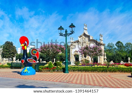 Rooster of Barcelos (Galo de Barcelos) and colorful garden in the background. Portugal