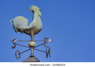 Rooster weather vane over blue sky - Powered by Shutterstock