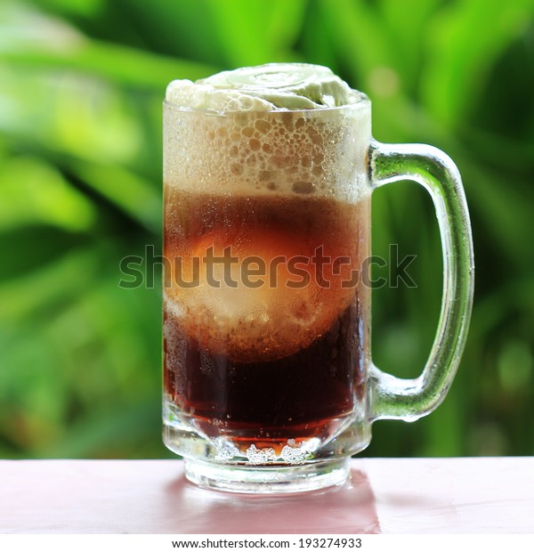 Root beer float a tasty summer treat on Green\
tree background