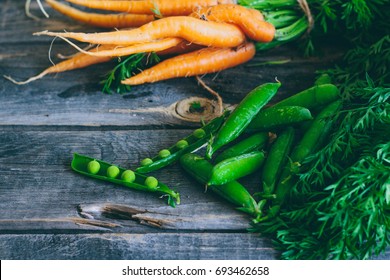 Roots, Fresh Vegetables, Carrots And Peas With A Pod, On A Wooden Background, Agronomy