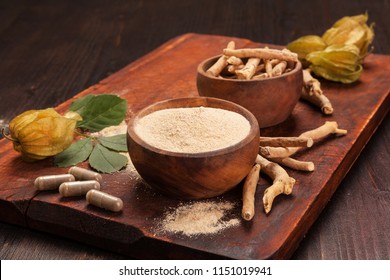 Roots and powder of Ashwagandha also known as Indian ginseng on wooden background. Hair loss, anti cancer, testosteron and depression benefits.