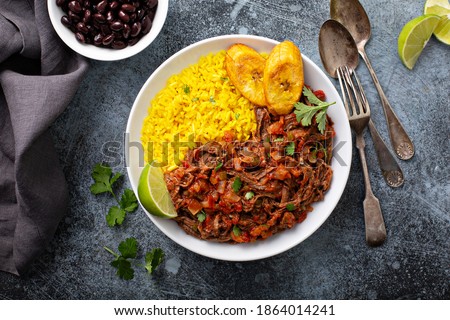 Ropa vieja, traditional flank steak dish with rice, cuban beans and plantains
