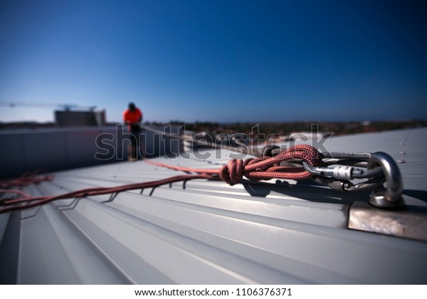 Rope access height safety carabiners connecting
with figure of eight knots rigging, clipping into roof fall arrest
and fall restraint anchor point systems ready to ascending,
construction site Sydney