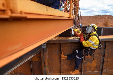 Rope access painter maintenance abseiler wearing fall safety body harness helmet protective gear applying spraying first coating with cane rust proof paint protection construction site, Australia  
 - Powered by Shutterstock