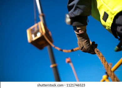 Rope Access Rigger Worker Commencing High Risk Job Wearing Heavy Duty Glove Holding A Safety Tag Line Rope To Control Load Swing While Crane Is Lifting In Construction Building Site, Perth Australia 
