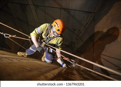 Rope Access Technician Inspector Non Destructive Testing (NDT) Wearing Fall Body Safety Harness, Safety Helmet Precisely Conducting Chute Bin Preparation Prior Inspection, Perth Mine Site, Australia 