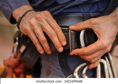 Rope access technician male hand inspector commencing inspecting, fastening industrial fall body abseiling  safety harness buckle belt strap prior used - Powered by Shutterstock