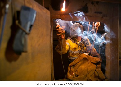 Rope Access Welder Wearing Fully Safety Uniform Fall Protection Helmet, Welding Glove Harness, Commencing Welding  Chute Repair In Confined Space Construction Mine Site Perth Pilbara Region Australia 