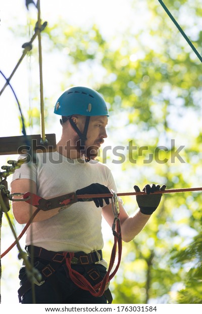 Rope adventure - man about to walk on the\
suspension rope bridge