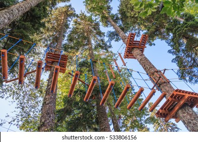 Rope Adventure Park In A Summer Forest Scenic Blue Sky Scenery. Overcoming Obstacles And Reaching Heights Abstract Concept