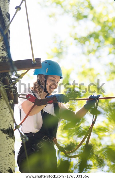 Rope adventure - smiling woman walks on the
suspension rope bridge