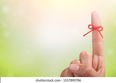Rope bow on finger pointing  up on background